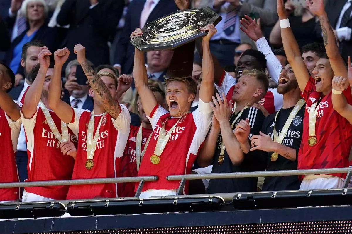 Arsenal's Martin Odegaard (centre) and team-mates lift the trophy after the FA Community Shield