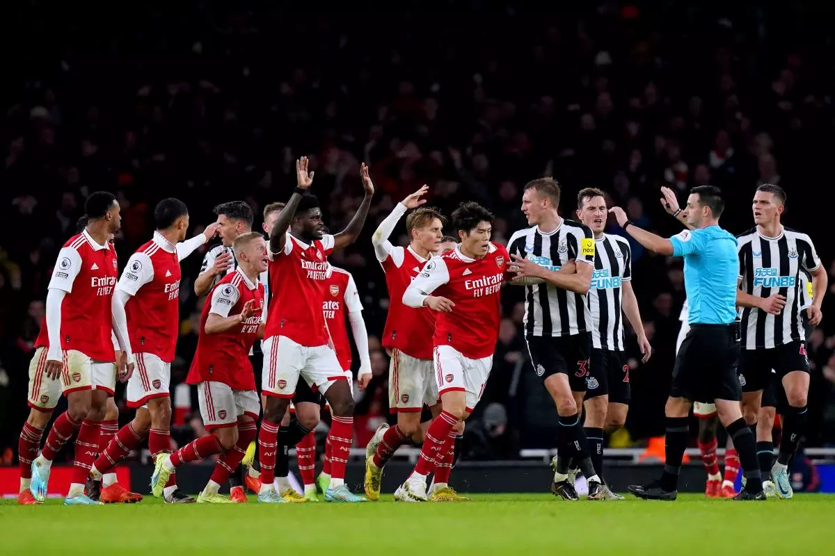Arsenal players surround referee Andrew Madley as they appeal for a hand ball during the Premier League match against Newcastle