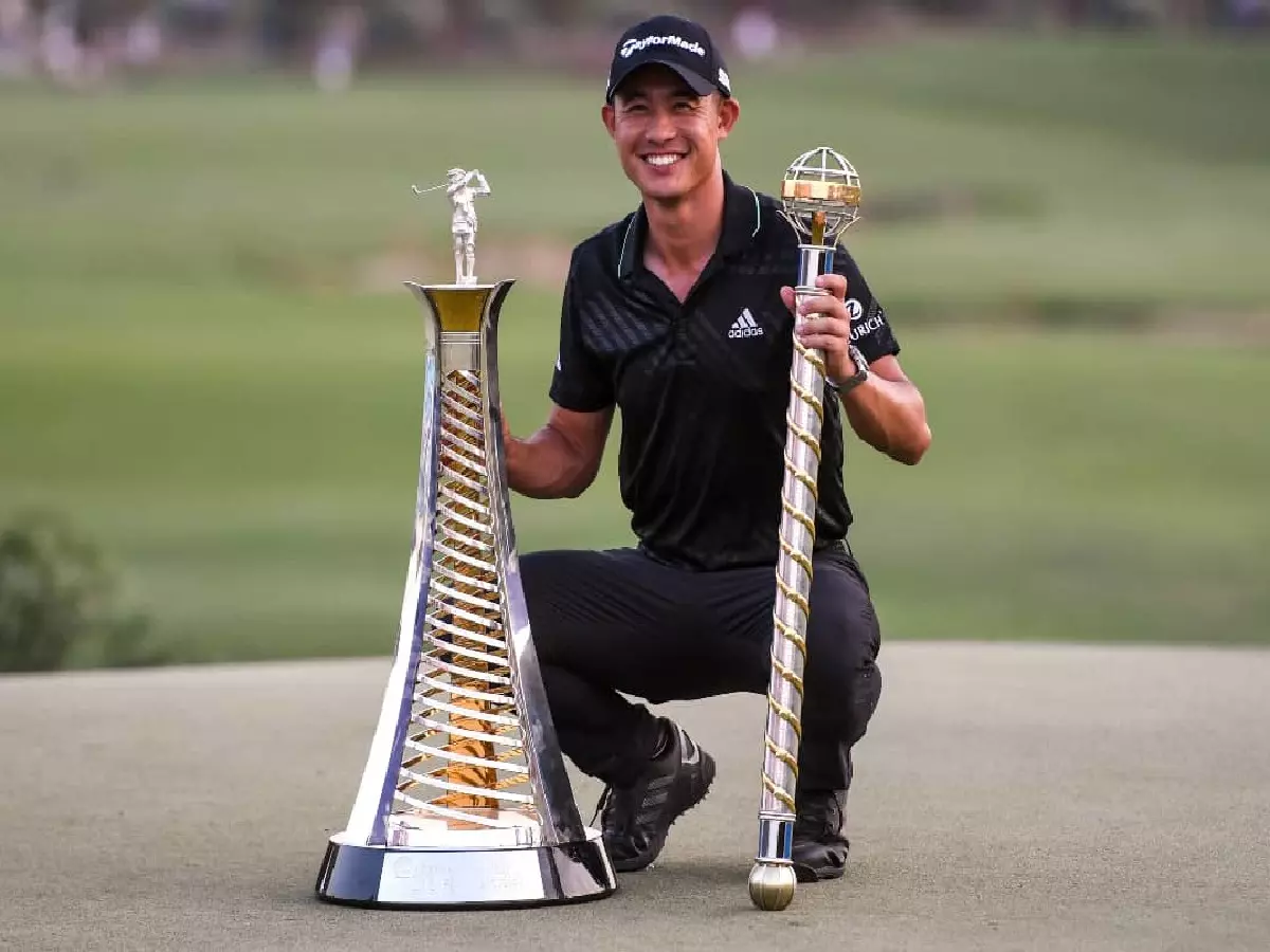 Collin Morikawa with the Race to Dubai and DP World Championship trophies