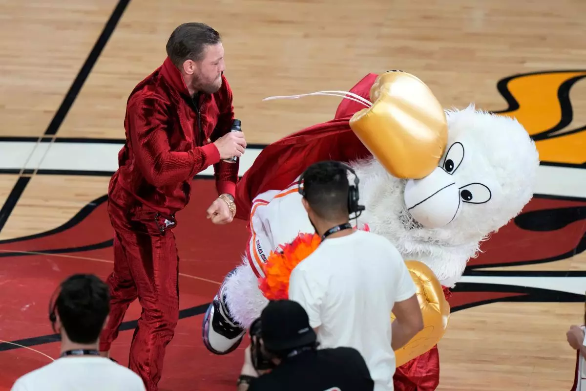 Former MMA fighter Conor McGregor punches Burnie, the Miami Heat mascot