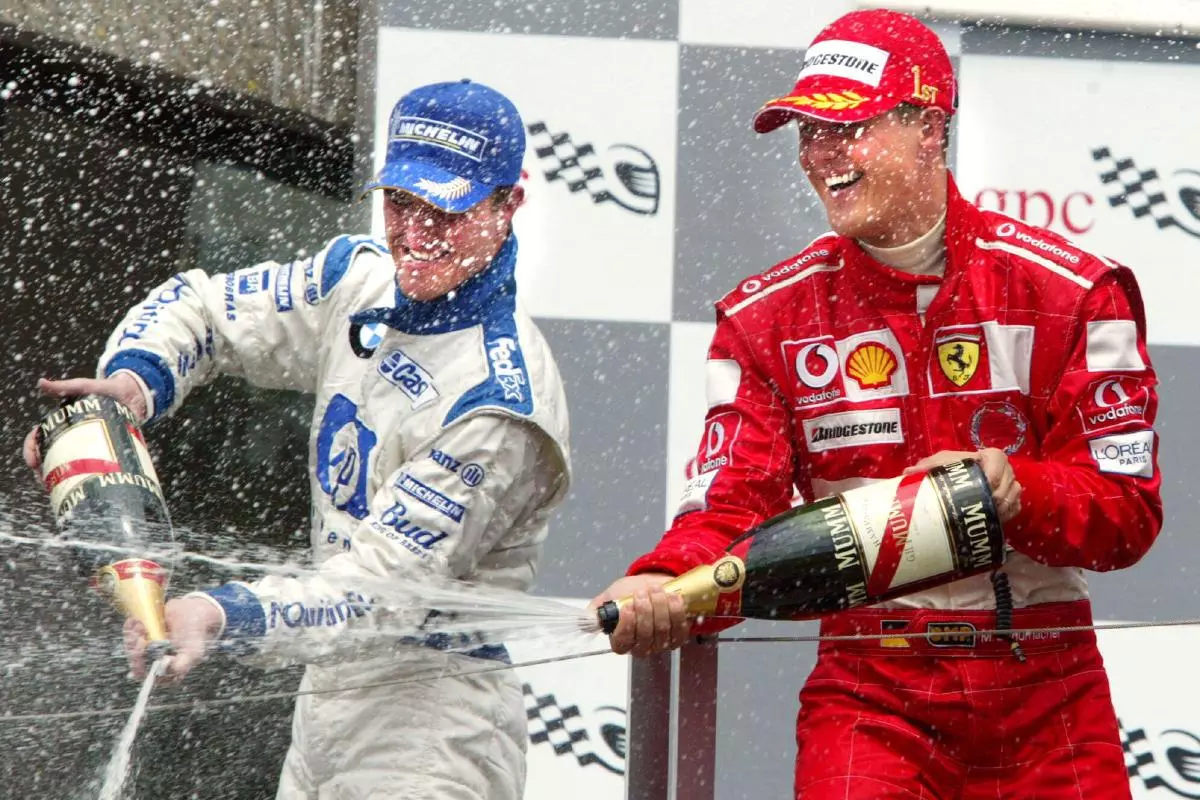 Germany's Michael Schumacher, right, with Ferrari celebrates his victory along with his brother and second-place finisher Ralf Schumacher