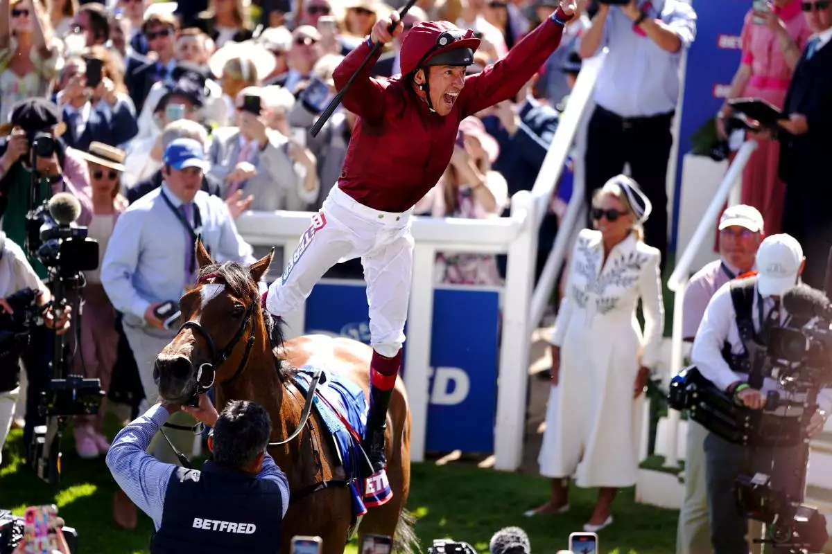 Jockey Frankie Dettori leaps off of Soul Sister as he celebrates winning the Betfred Oaks