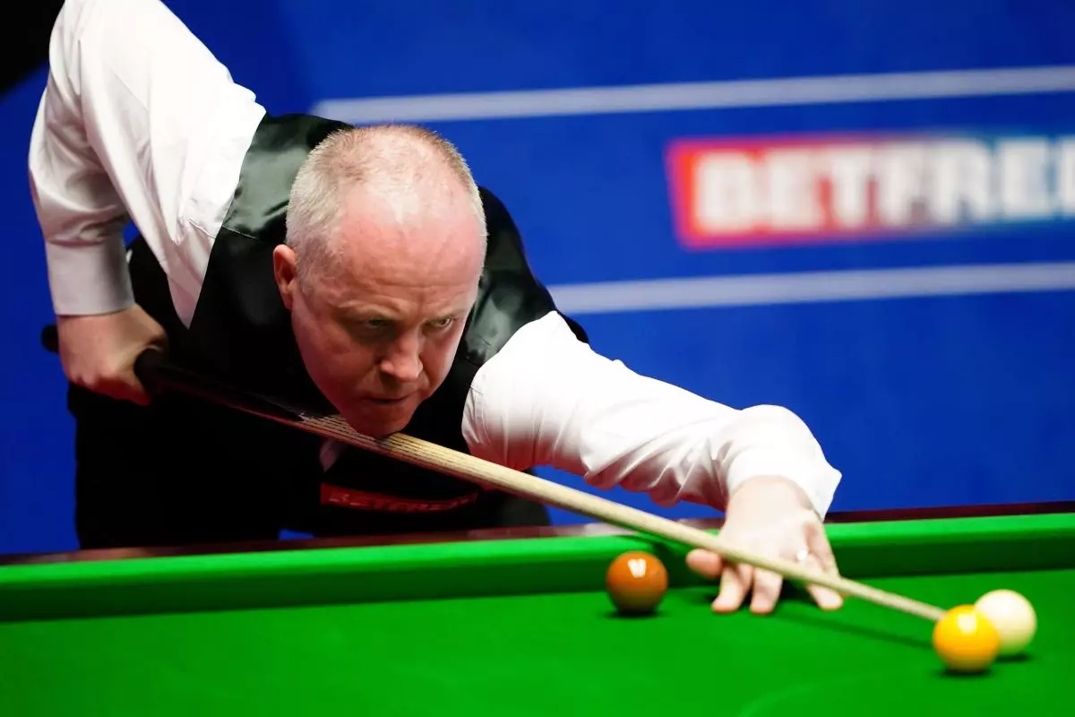 Scotland's John Higgins in action against Thailand's Noppon Saengkham during day nine of the Betfred World Snooker Championships at The Crucible