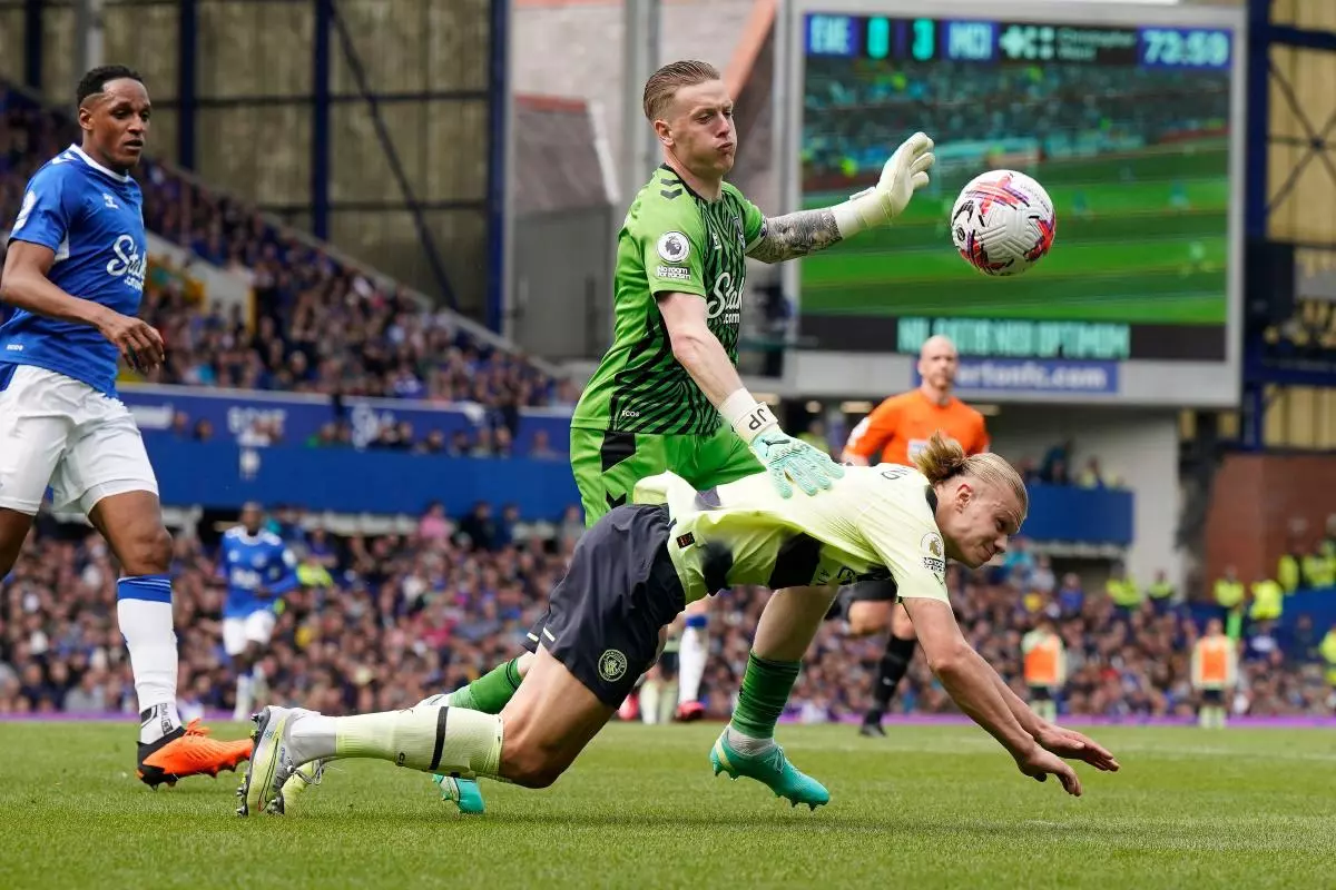 Jordan Pickford of Everton (c) challenges Erling Haaland of Manchester City