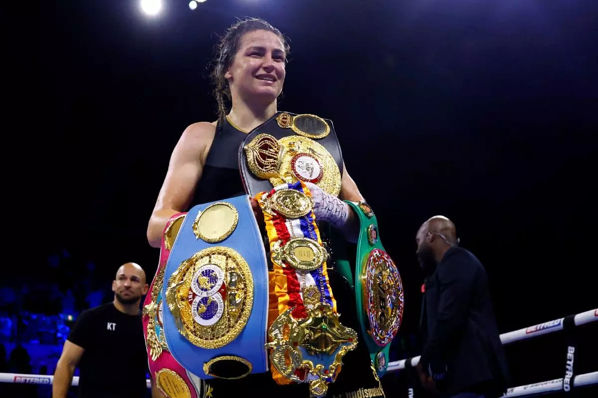 Katie Taylor celebrates with her belts after beating Karen Carabajal to win their Undisputed Lightweight World Title fight at the OVO Arena Wembley