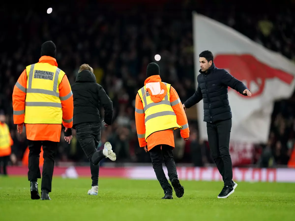 Mikel Arteta chases off a pitch invader during Arsenal's game vs West Ham