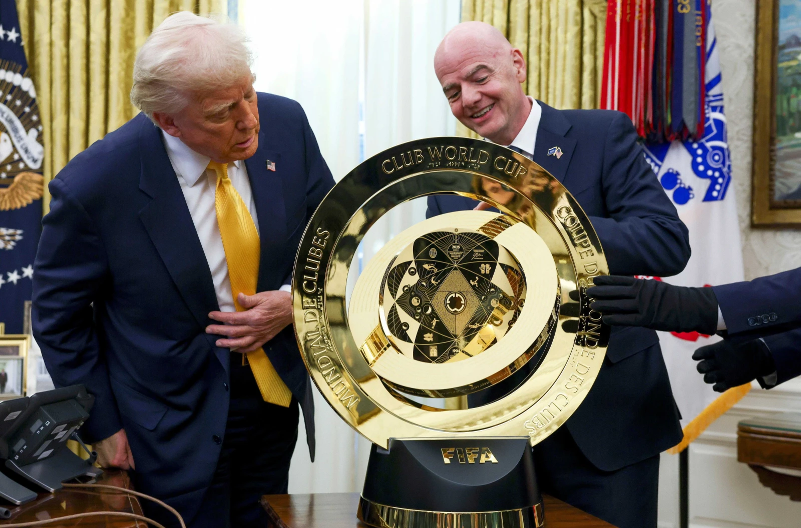 President Donald Trump and FIFA President Gianni Infantino stand next to the FIFA Club World Cup trophy
